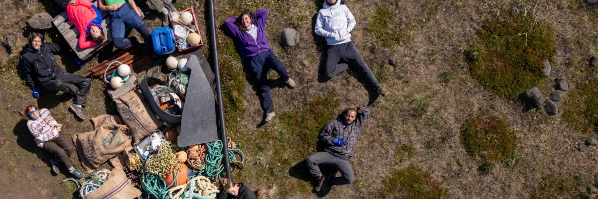 Volontari del workcamp in Islanda riposano accanto ai rifiuti raccolti sulla costa — foto dall'alto