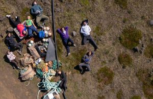 Volontari del workcamp in Islanda riposano accanto ai rifiuti raccolti sulla costa — foto dall'alto